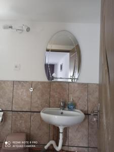 La salle de bains est pourvue d'un lavabo et d'un miroir. dans l'établissement Casa Calix, à Băile Govora