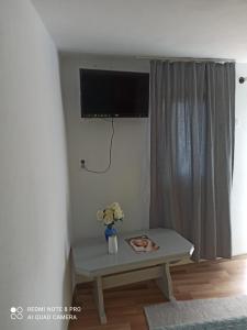 uma sala de estar com uma mesa e uma televisão na parede em Casa Calix em Baile Govora
