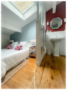 a bedroom with a white bed and a sink at LES CHAMBRES DE MARIE in Bordeaux