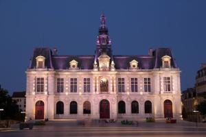 un gran edificio blanco con una torre de reloj en la parte superior en • Bel appartement - centre historique de Poitiers en Poitiers