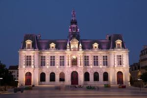 un grand bâtiment blanc avec une tour d'horloge en haut dans l'établissement • Bel appartement - centre historique de Poitiers, à Poitiers