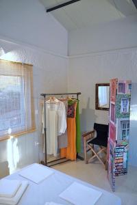een kamer met een bed en een kledingrek in een kamer bij Figs & Grapes * Cosy small house * Marmari * South Evia in Marmarion