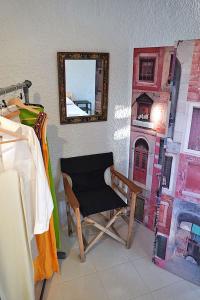 Habitación con silla y espejo en la pared. en Figs & Grapes * Cosy small house * Marmari * South Evia en Marmarion