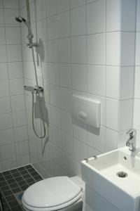 y baño con ducha, aseo y lavamanos. en Hotel PerOlofGården, en Åsbro