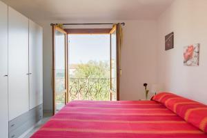 a bedroom with a large pink bed with a large window at Le Bouganville in Santa Maria Navarrese