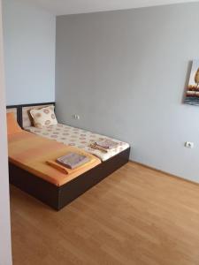 ein kleines Bett in einem Zimmer mit Holzboden in der Unterkunft Апарт хотел Мелани in Plowdiw