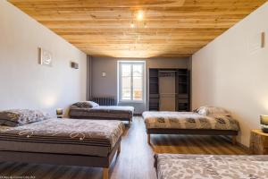 3 łóżka w pokoju z drewnianym sufitem w obiekcie Gîte de la Combe Farbet w mieście Darcey