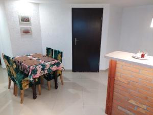 a dining room with a table and chairs and a black door at Mazurska Piwniczka in Giżycko