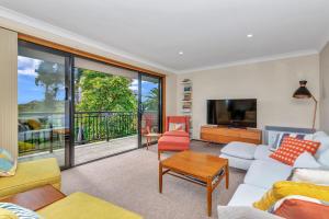 a living room with a couch and a tv at Port of Call - Port Willunga - C21 SouthCoast Holidays in Port Willunga