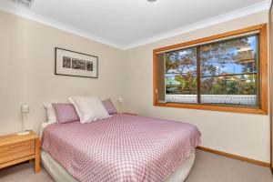 Schlafzimmer mit einem Bett und einem Fenster in der Unterkunft Port of Call - Port Willunga - C21 SouthCoast Holidays in Port Willunga