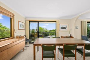 a living room with a wooden table and chairs at Port of Call - Port Willunga - C21 SouthCoast Holidays in Port Willunga