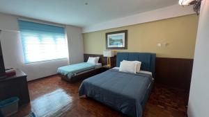 um quarto de hotel com duas camas e uma janela em Condo D'Savoy @ Famosa, Malacca em Malaca