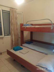 two bunk beds in a room with a window at Ήσυχο οικογενειακό σπίτι. in Astros