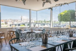 uma sala com mesas e cadeiras com copos de vinho em Fleur de Loire em Blois
