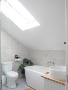 a bathroom with a white tub and a toilet and a sink at Coorie Away - Kirkcudbright in Kirkcudbright