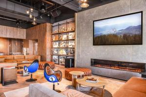 a lobby with a fireplace and a tv on the wall at Villars Palace in Villars-sur-Ollon