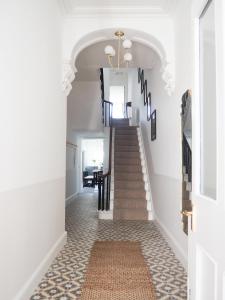 a hallway with a staircase with white walls at Coorie Away - Kirkcudbright in Kirkcudbright
