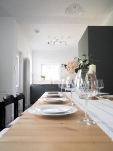 a dining room table with plates and wine glasses at Coorie Away - Kirkcudbright in Kirkcudbright
