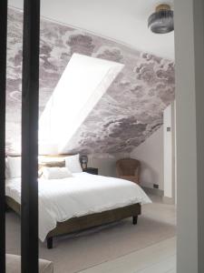 a bedroom with a large bed with a cloud mural on the ceiling at Coorie Away - Kirkcudbright in Kirkcudbright