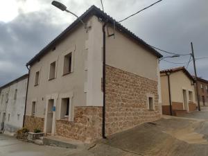 ein weißes Backsteingebäude mit Straßenbeleuchtung daneben in der Unterkunft CASA DEL ABUELO Viana de Duero Soria in Viana de Duero