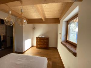 a bedroom with a bed and a window and a dresser at La Croche - Lo Marmotin in Chamois