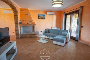 een woonkamer met een bank en een tv bij La casa in Terralba