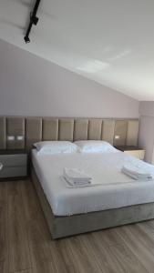 a bedroom with a large bed with white sheets at Rezidenca Oliva in Vlorë