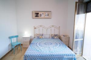 una camera con un letto blu e una sedia blu di Monolocale ilporticciolovacanze a Villanova