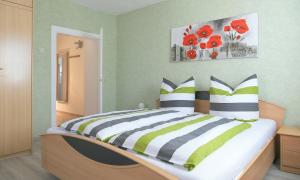 1 dormitorio con 1 cama con flores rojas en la pared en Ferienwohnung Bodenstein, en Bad Liebenstein