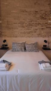a large white bed with two pillows on it at Carmona&House in Seville
