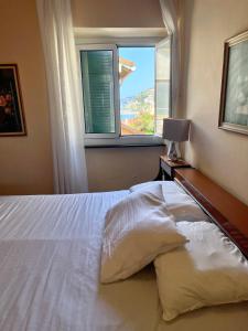 a bedroom with a large white bed with a window at Borgo Prino in Imperia