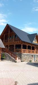 a large log cabin with a black roof at Pensiunea Teodora Breb Maramu in Breb