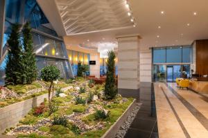 einen Garten in der Lobby eines Bürogebäudes in der Unterkunft Fraser Suites Doha in Doha