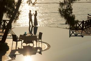 a bride and groom standing next to the water at Liberty Lykia Adults Only in Oludeniz