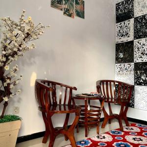 two wooden chairs and a table in a room at Kayz Villa Batu dengan Kolam Renang Pribadi in Batu