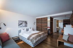 una camera con un grande letto e un soggiorno di Residence Villa Calluna a Campo Tures