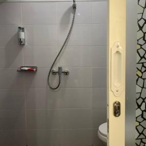 a shower in a bathroom with a toilet at Kayz Villa Batu dengan Kolam Renang Pribadi in Batu