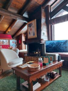 a living room with a table and a fireplace at Baita LE SERE in Sestriere