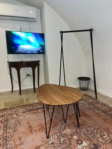 a living room with a table and a tv and a table at Tish Hotel in Jerusalem