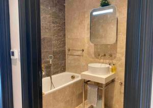 a bathroom with a sink and a tub and a mirror at Bright & Modern 2 bedroom In Hendon in Hendon