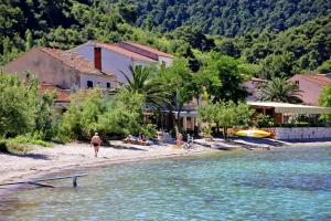 a group of people on a beach near a body of water at Apartments and rooms by the sea Zuljana, Peljesac - 256 in Žuljana