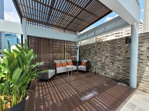 a patio with a wooden deck with chairs and a brick wall at Citrus Suites Sukhumvit 6 by Compass Hospitality in Bangkok