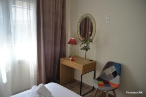 1 dormitorio con cama, escritorio y espejo en kynosargous square's apartment, en Atenas