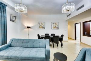 een woonkamer met een blauwe bank en een tafel bij Great Family apartment near the JBR beach in Dubai