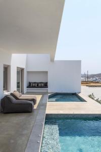 a living room with a swimming pool and a house at Muro Suites in Ornos