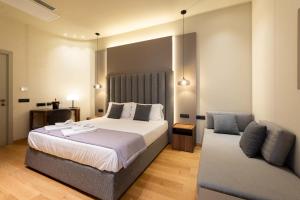 a bedroom with a large bed and a couch at ELICAL Exclusive Private Suites in Rome
