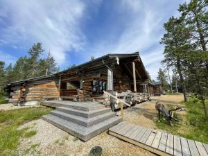 a log cabin with stairs in front of it at Tunturipöllö / Lapland, Saariselkä in Saariselka