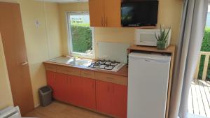 a small kitchen with a sink and a microwave at Bienvenue chez Anaïs ! in Biville-sur-Mer