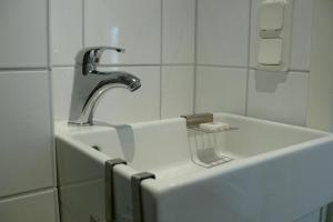 a sink with a faucet in a bathroom at Hotel PerOlofGården in Åsbro