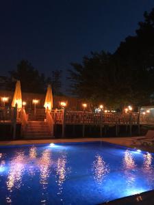 a swimming pool at night with lights in the background at Dream Town Hotel&Restaurant in Kemer